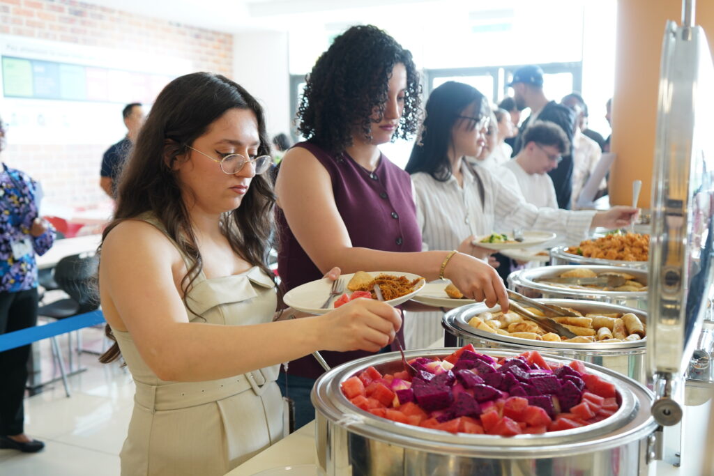 Étudiantes et étudiants participant à un programme international en Malaisie se servent au buffet lors d'un petit-déjeuner d'accueil sur le campus de Heriot-Watt University Malaysia à Putrajaya.
